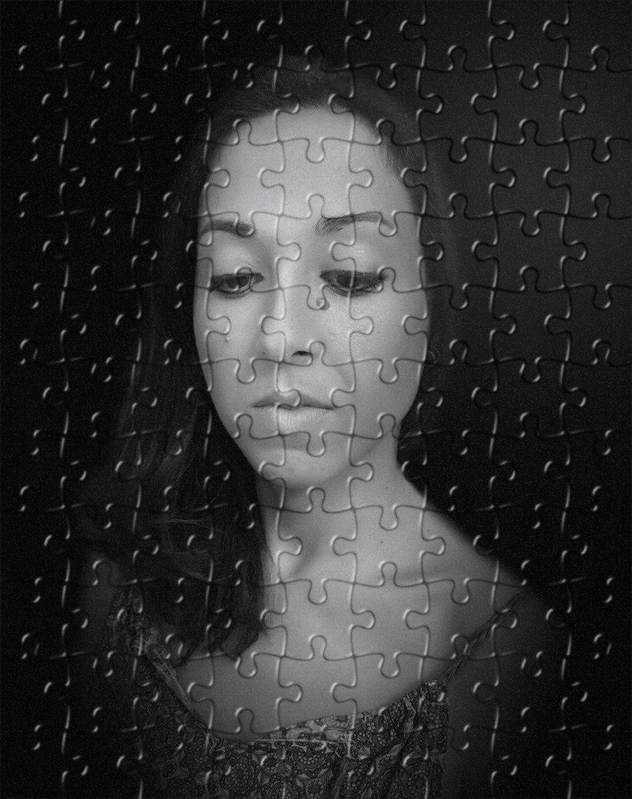 A monochromatic portrait of founder Sonia Perez partially obscured by an overlay of puzzle pieces, conveying a sense of introspection and complexity.